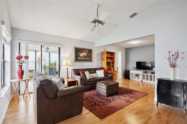 living room featuring ceiling fan, light hardwood / wood-style floors, a textured ceiling, and high vaulted ceiling