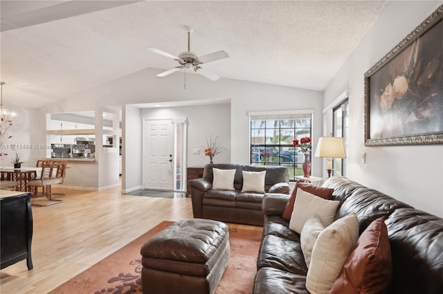 living room featuring hardwood / wood-style floors, a textured ceiling, vaulted ceiling, and ceiling fan