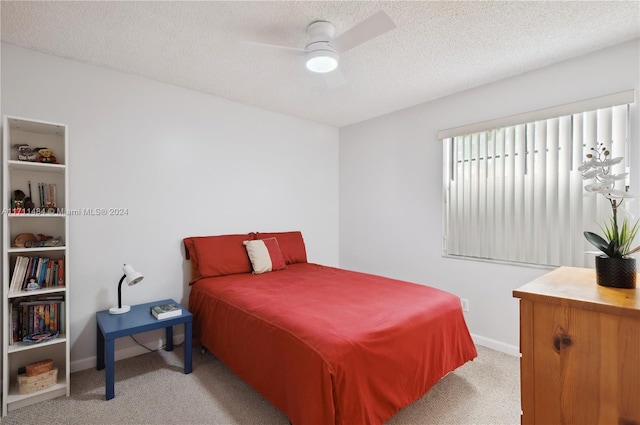 carpeted bedroom with ceiling fan and a textured ceiling