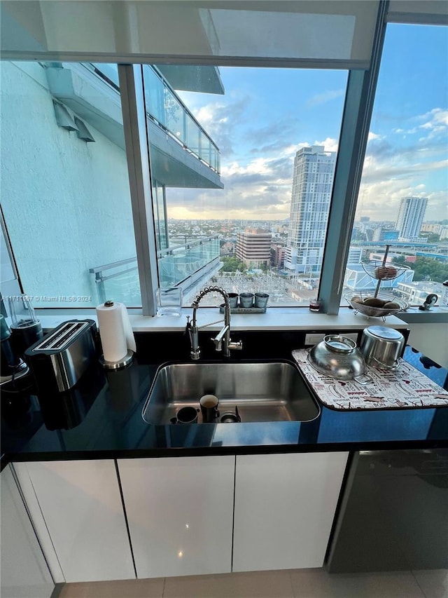 kitchen with white cabinets, plenty of natural light, and sink