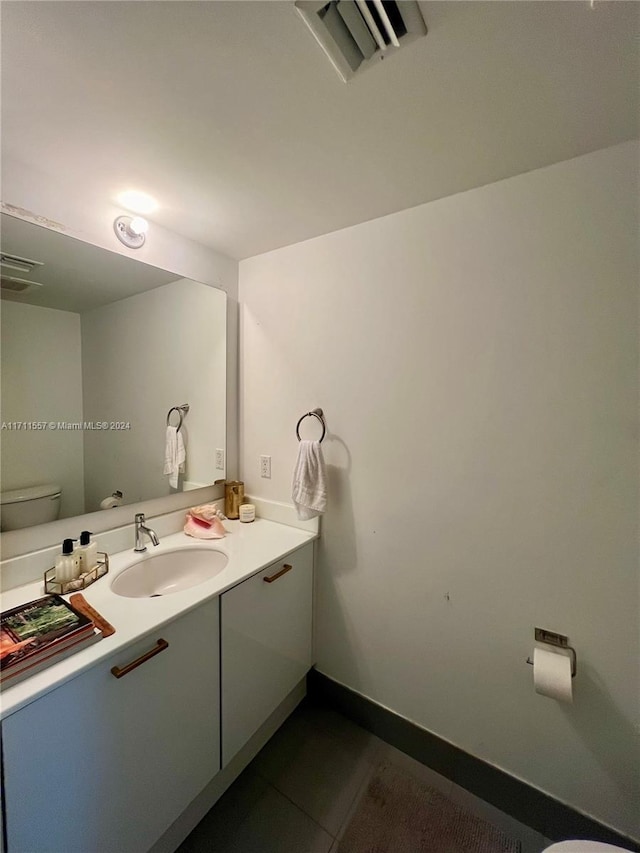 bathroom featuring tile patterned flooring, vanity, and toilet