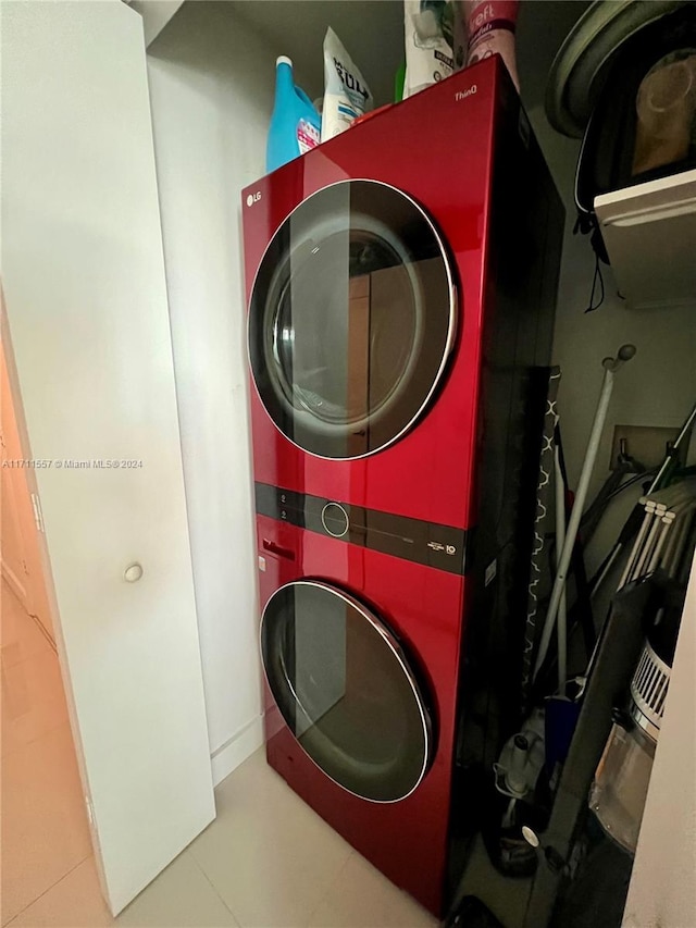 laundry room featuring tile patterned flooring and stacked washing maching and dryer