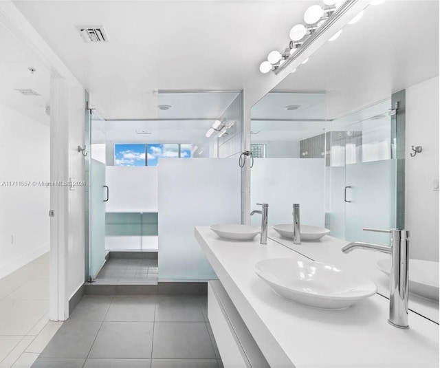 bathroom with tile patterned flooring, vanity, and a shower with door