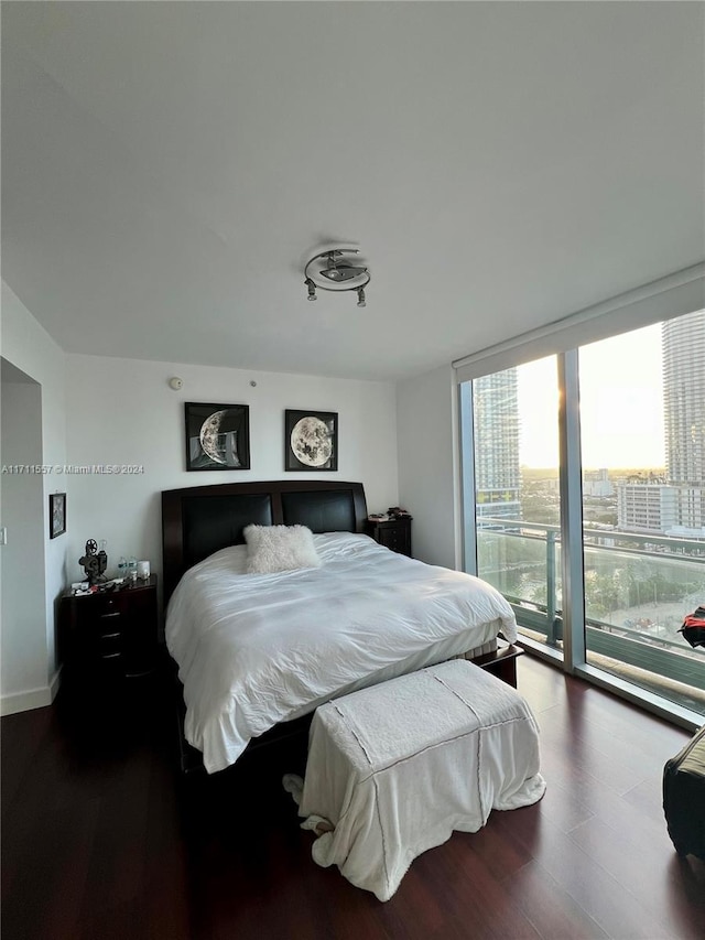 bedroom with access to exterior and dark hardwood / wood-style flooring