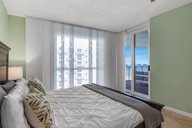 bedroom with light tile patterned flooring, a textured ceiling, and access to outside