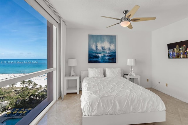 bedroom featuring a water view and ceiling fan