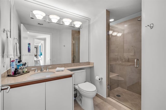 bathroom featuring tile patterned flooring, vanity, an enclosed shower, and toilet