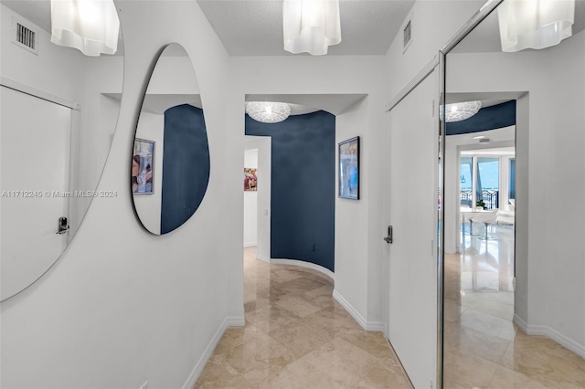 hall featuring a textured ceiling