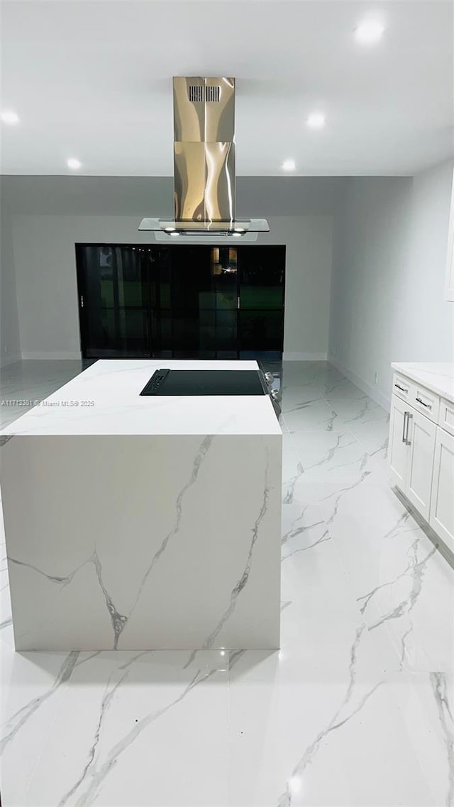 kitchen with a kitchen island, island range hood, and white cabinets