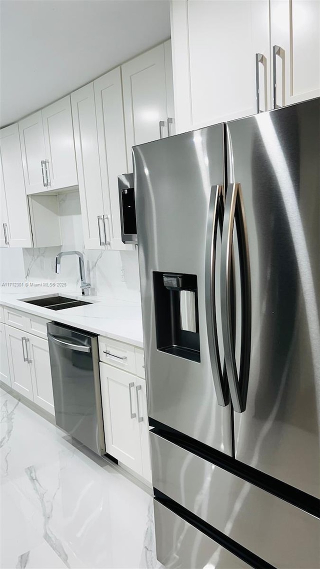 kitchen featuring backsplash, sink, white cabinets, and appliances with stainless steel finishes