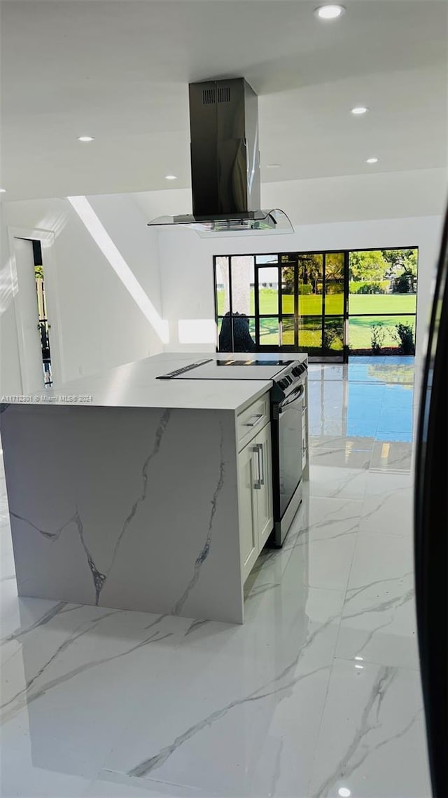 kitchen with island range hood, electric stove, a kitchen island, white cabinets, and light stone counters