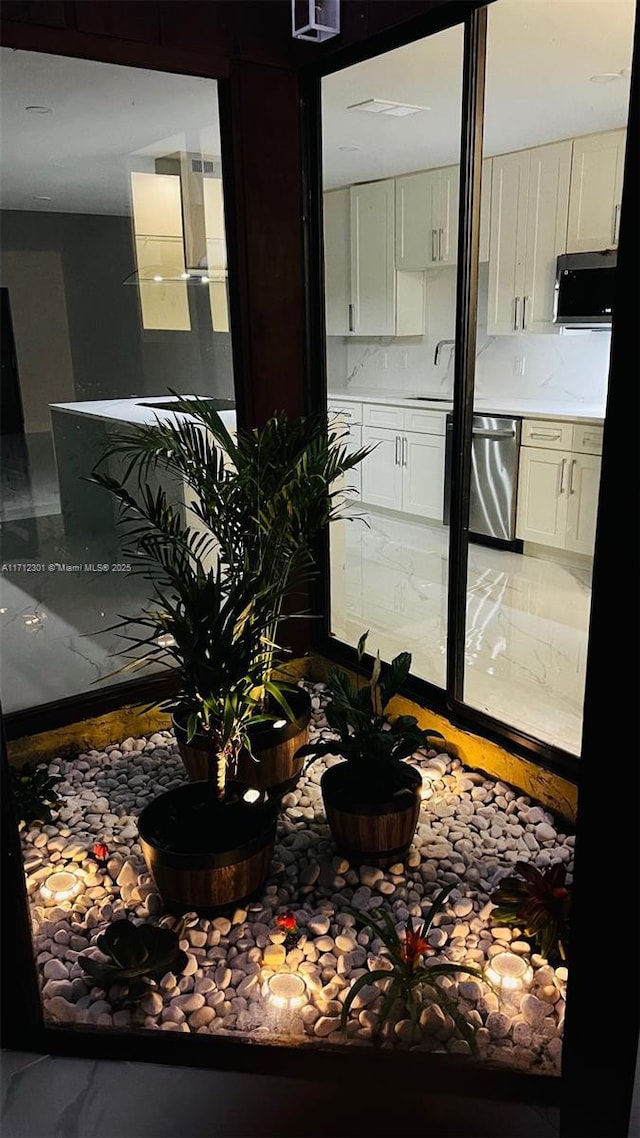 room details featuring stainless steel dishwasher, tasteful backsplash, and sink