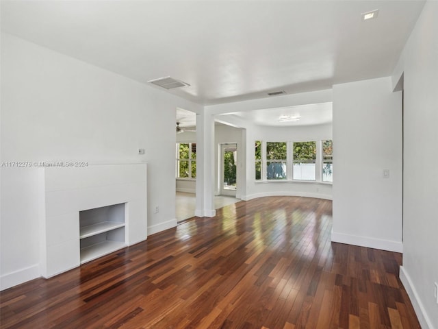 unfurnished living room with dark hardwood / wood-style floors and ceiling fan