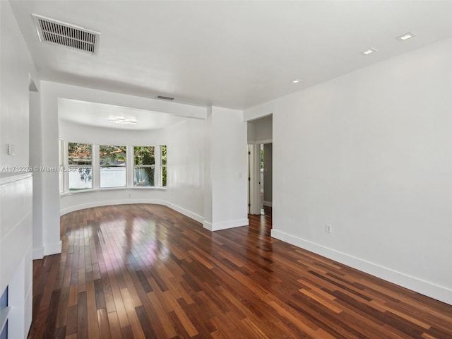 unfurnished room with dark wood-type flooring