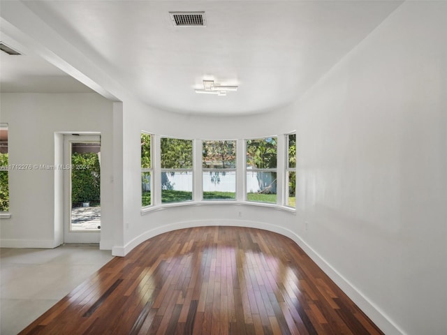 unfurnished room featuring hardwood / wood-style floors and a wealth of natural light