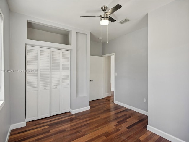 unfurnished bedroom with ceiling fan, dark wood-type flooring, and a closet