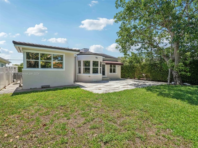 back of property featuring a patio and a lawn