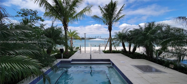 view of swimming pool featuring a water view and a patio