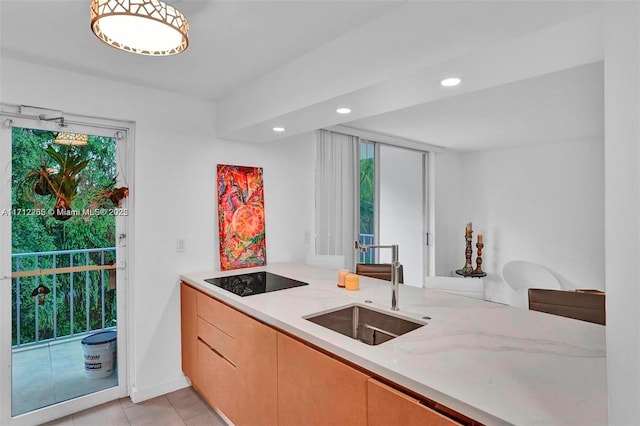 kitchen featuring sink, light tile patterned floors, light stone countertops, black electric cooktop, and light brown cabinetry