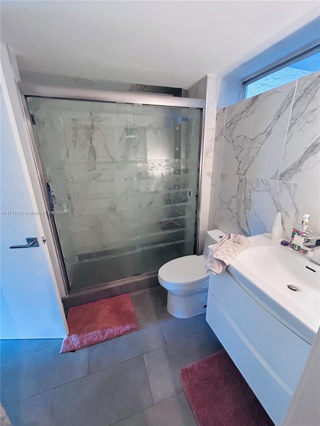 bathroom with walk in shower, vanity, tile walls, and toilet