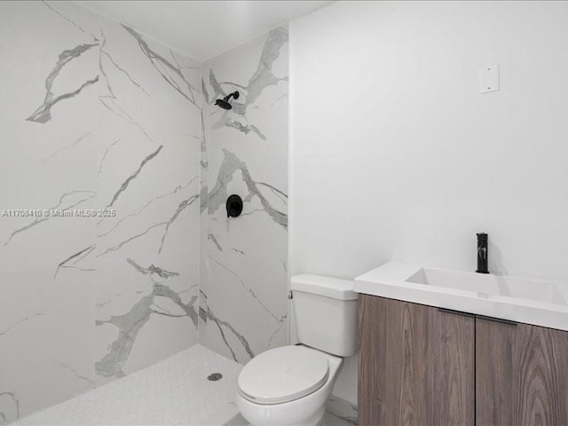 bathroom with toilet, a marble finish shower, and vanity