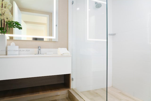 bathroom featuring a tile shower and vanity