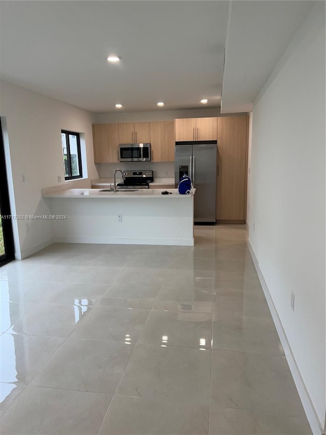 kitchen with kitchen peninsula, stainless steel appliances, and sink