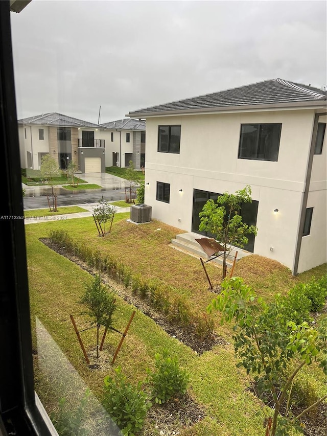 exterior space with cooling unit and a yard