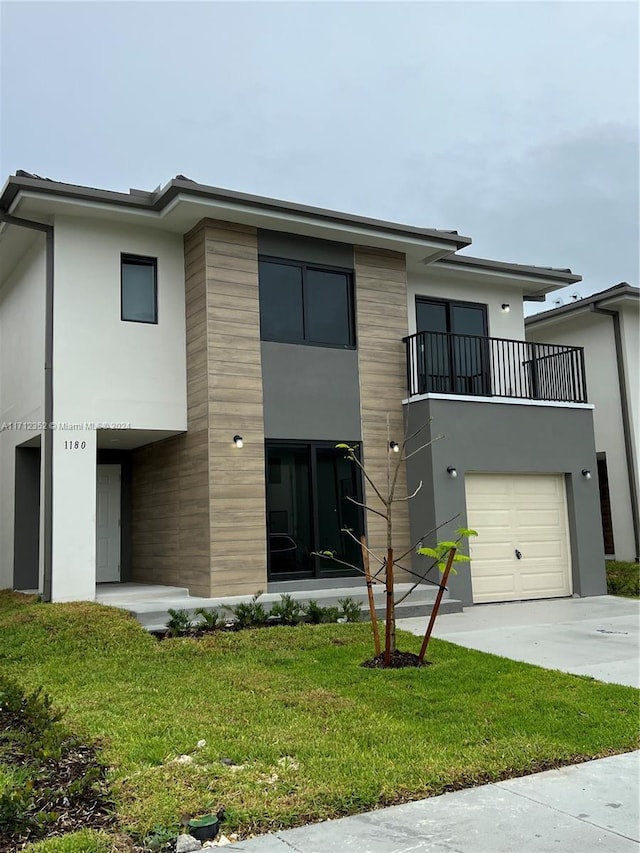 view of front of home with a garage, a balcony, and a front yard