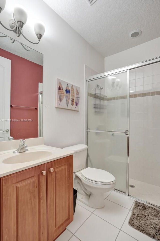 bathroom with toilet, a textured ceiling, vanity, and tile patterned floors