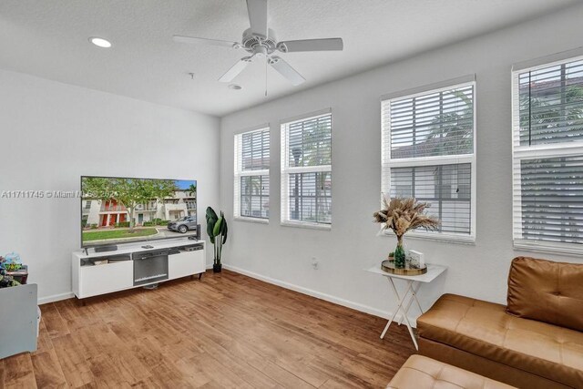 living room featuring light hardwood / wood-style flooring and ceiling fan