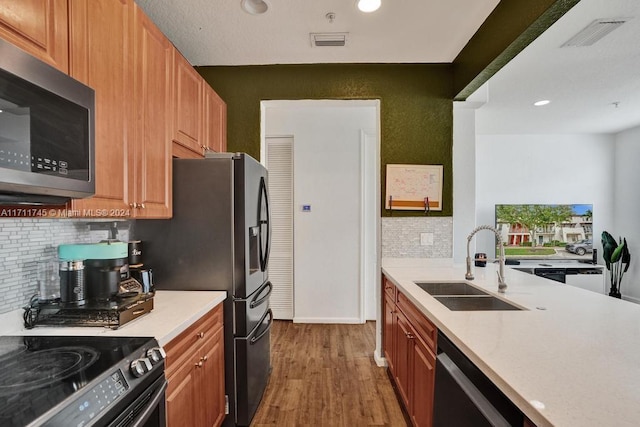 kitchen featuring backsplash, sink, stainless steel appliances, and dark wood-type flooring