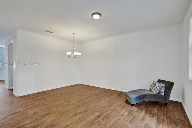 unfurnished room with a chandelier and hardwood / wood-style flooring