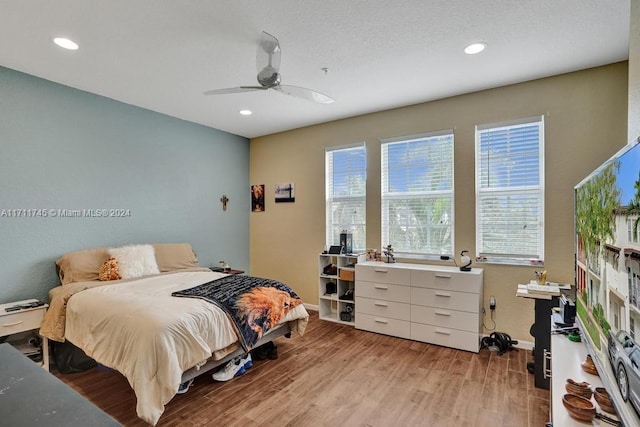 bedroom with light hardwood / wood-style floors, multiple windows, and ceiling fan