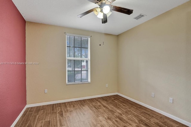 empty room with hardwood / wood-style floors and ceiling fan