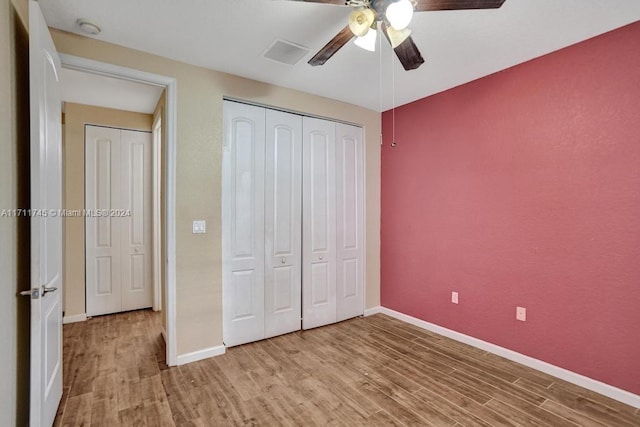 unfurnished bedroom with ceiling fan, light hardwood / wood-style floors, and a closet