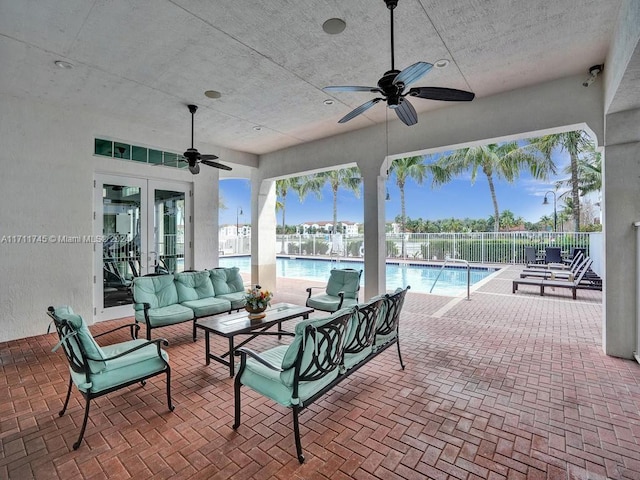 view of patio featuring a community pool, an outdoor living space, french doors, and ceiling fan