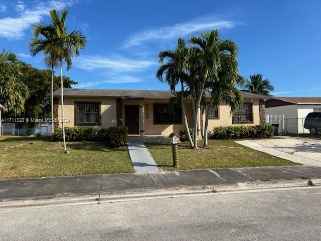 ranch-style home with a front yard and a carport