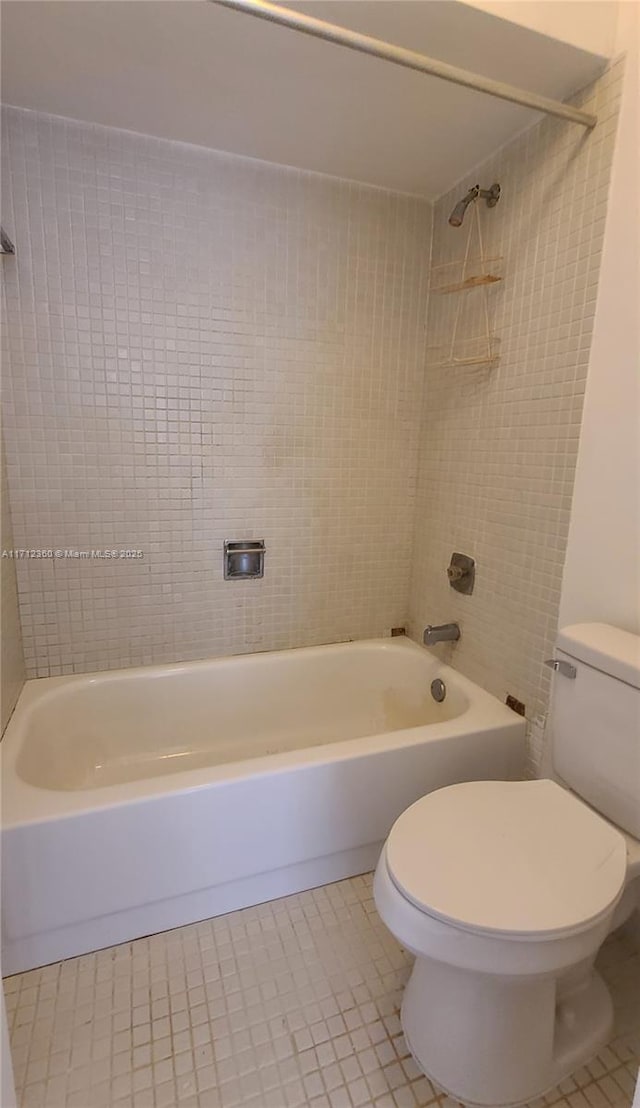 bathroom featuring toilet, tile patterned flooring, and shower / tub combination