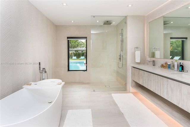 bathroom featuring vanity and shower with separate bathtub