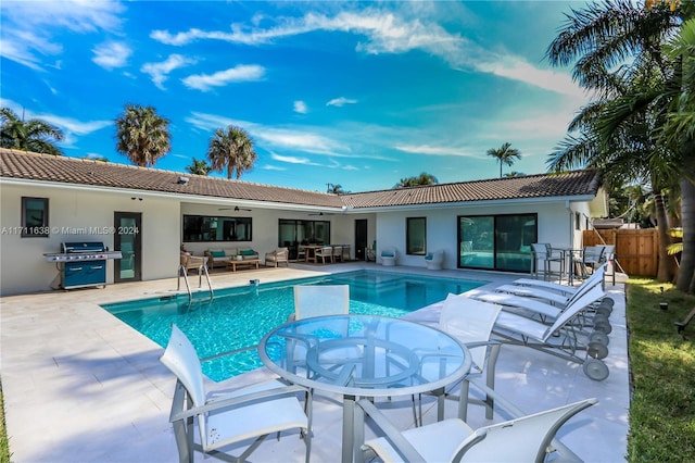 view of pool with an outdoor living space, grilling area, a patio area, and ceiling fan