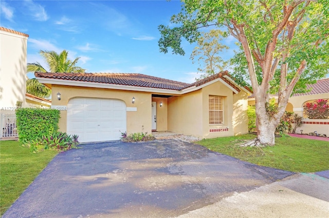 mediterranean / spanish home with a front lawn and a garage