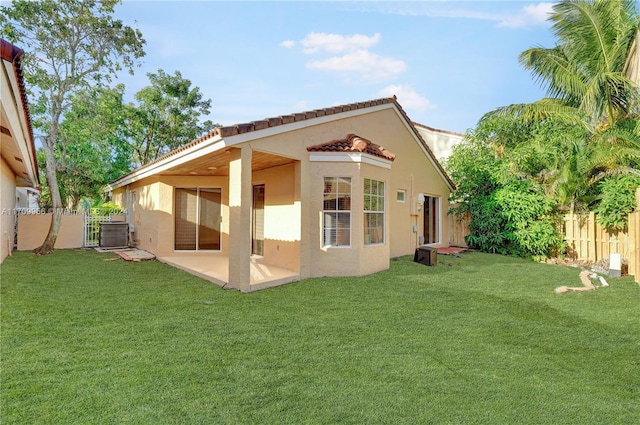 back of property featuring a lawn, central AC, and a patio