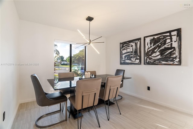 dining space with a notable chandelier and light hardwood / wood-style floors