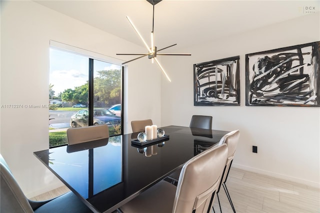 dining space featuring light wood-type flooring and a notable chandelier