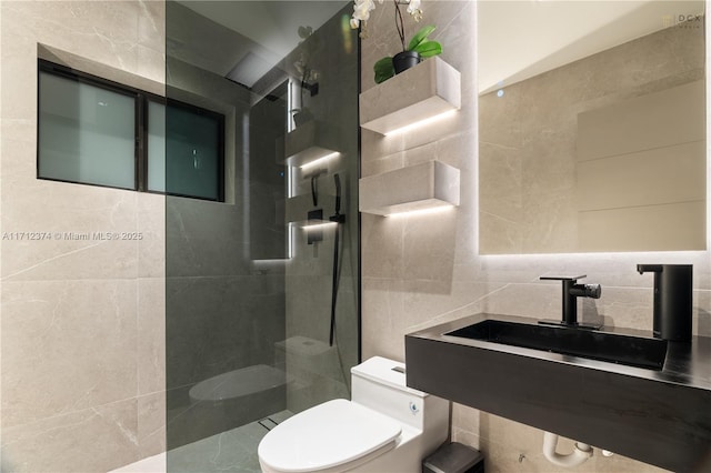 bathroom with sink, tile walls, tasteful backsplash, a tile shower, and toilet