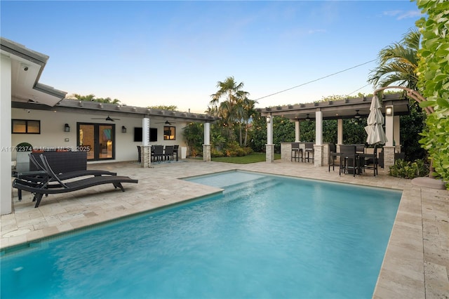 view of swimming pool featuring ceiling fan, exterior bar, an outdoor hangout area, and a patio