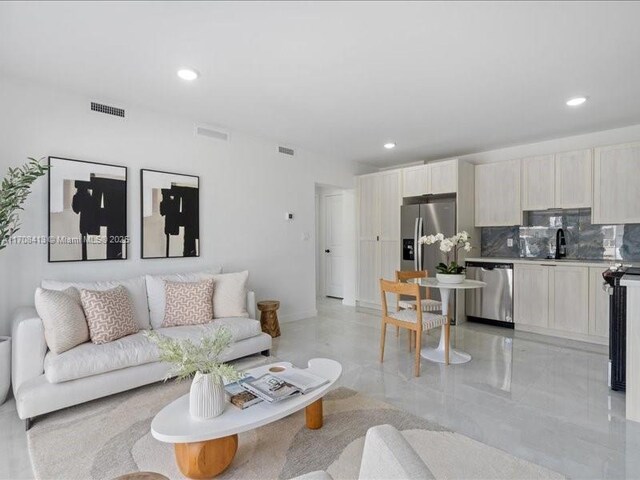 living area featuring baseboards, visible vents, and recessed lighting