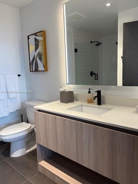 bathroom with tile patterned flooring, vanity, toilet, and an enclosed shower