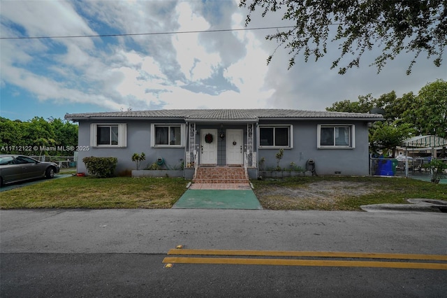 single story home featuring a front lawn